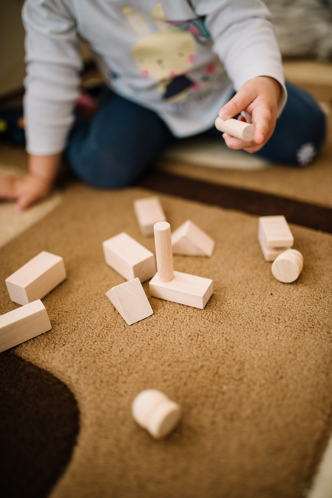 Manos de un niño jugando con bloques de madera