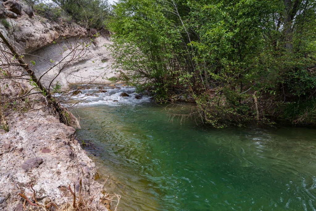 Río de aguas turquesas entre cerros y vegetación